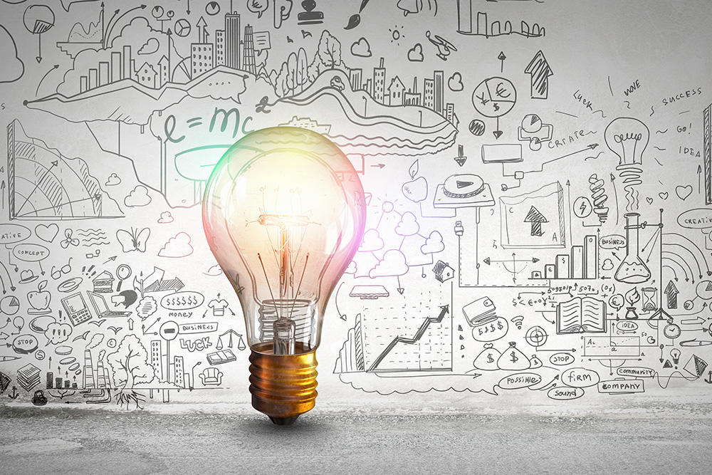 Illuminated light bulb surrounded by hand-drawn business ideas and diagrams.