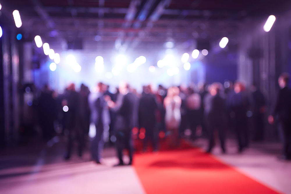 Guests gathered at a formal event beside a red carpet.